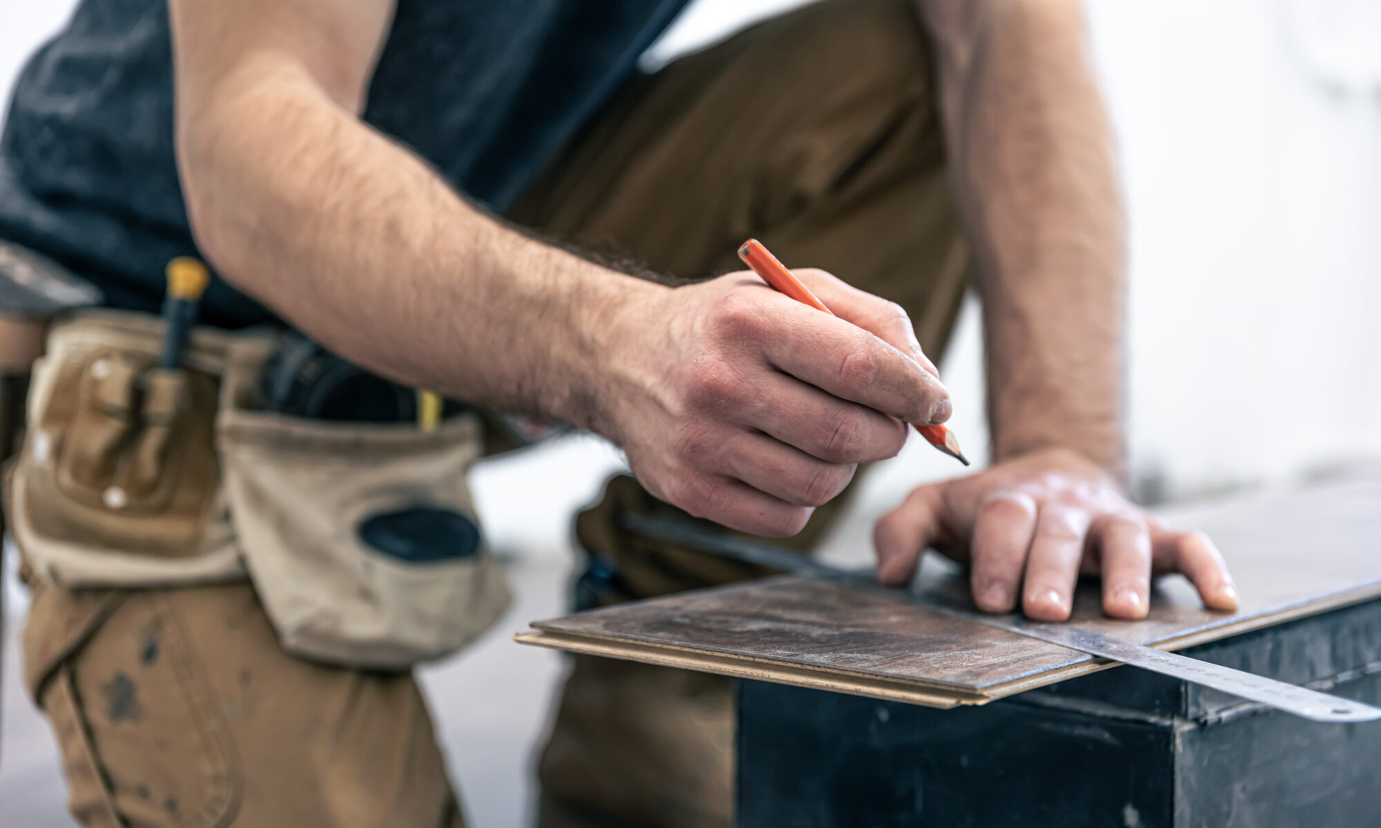 Bodenleger der ein Stück Laminat schneidet